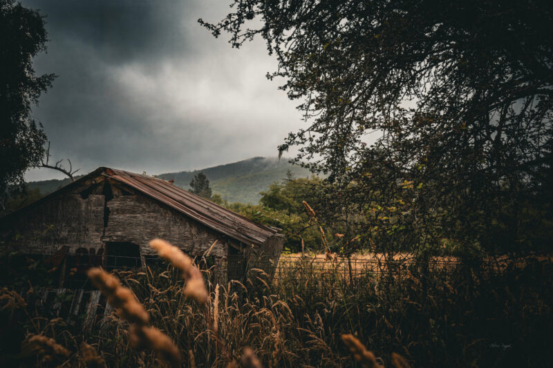 Stormy skies over old farm building, rural fine art photography